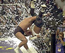 Choshu body slams Onita into barbed wire from Nikkan Sports
